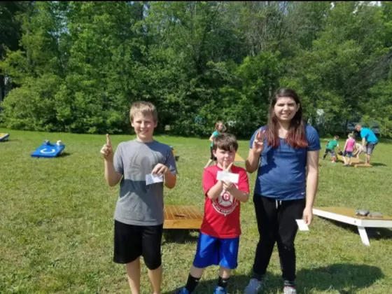 Kids corn hole tournament winners holding their prizes